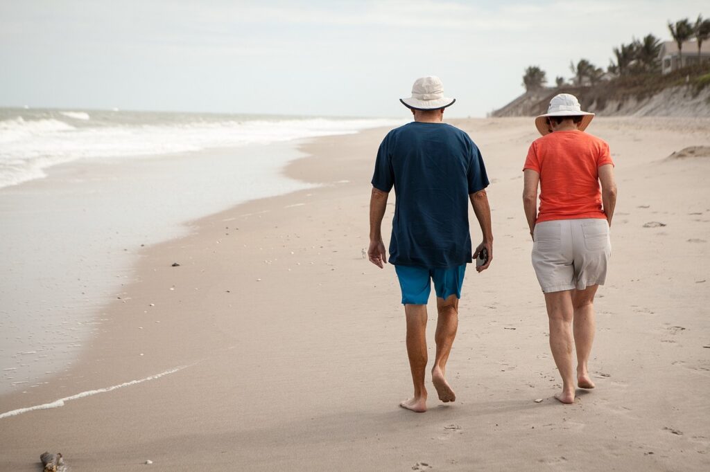 Couple with financial independence living a better life - walking on the beach