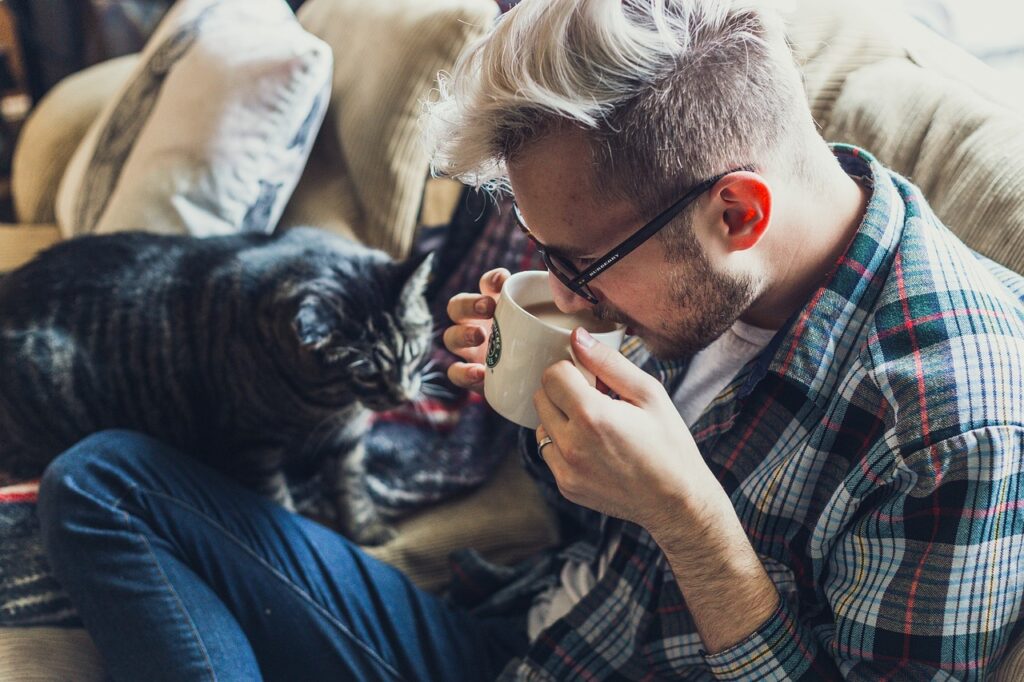 Man enjoying coffee and his cat